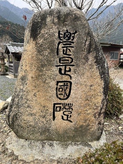 村に立つ石碑。篆書で四文字が刻まれている
